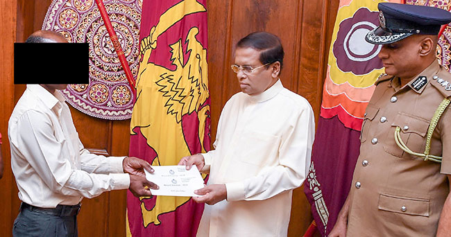 President hands over cash reward to lorry driver who helped seize explosives haul