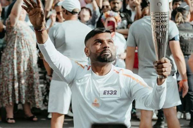 Sri Lankan-born baker Tharshan Selvarajah carries Olympic torch in France