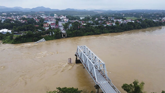 Flooding sweeps away a bus and a bridge collapses in Vietnam as storm deaths rise to 59