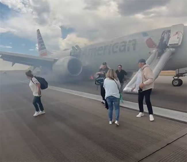 Passengers exit American Airlines flight via emergency slide after aborted takeoff