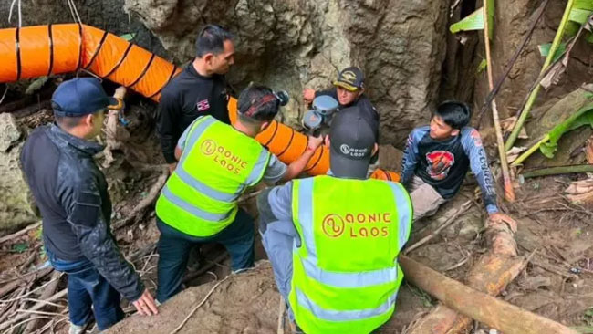 Rescuers race to free seven people trapped in flooded Laos cave